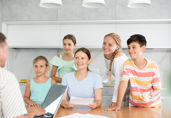 Solo mother with four children having visit of Social services officer sitting at their kitchen