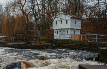 Historic white wooden traditional swedish house cottage by a rushing river in Mörrum, Skåne, Sweden. Countryside in Sweden.