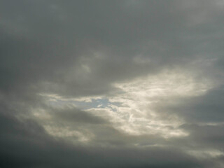 The sky is cloudy and the sun is not visible. The clouds are white and grey. The sky is blue and the clouds are scattered
