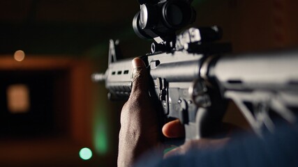 Man holds assault rifle, enjoying recreational shooting experience in firing range. Person practices with semiautomatic weapon in safe environment at shooting range company, camera A extreme close up