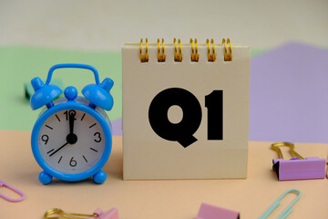 Close up of white notebook with alphabet Q1 on office desk. first quarter concept.