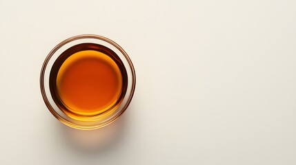A small clear glass bowl is filled with amber liquid