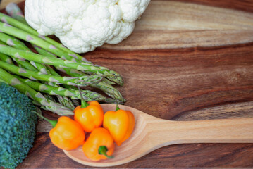 Fresh vegetables with habanero peppers and tomatillos on a rustic wooden surface
