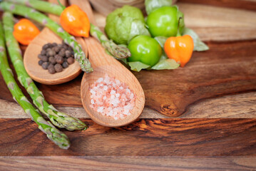 Assorted fresh vegetables and spices on a wooden background