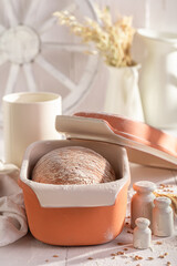 Homemade and fresh loaf of bread baking in with grain.