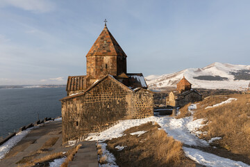 Fototapeta premium Sevanavank Monastery on the Sevan Peninsula during a cold early winter morning, at sunrise, overlooking the vast Lake Sevan. One of Armenia’s most popular travel and cultural destinations