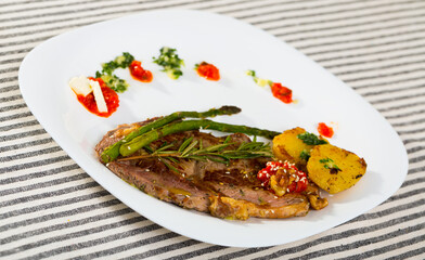 Homemade veal steak with grilled zucchini, tomato, asparagus