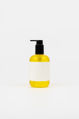 Yellow liquid soap in pump bottle on white background