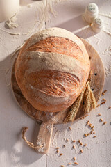 Hot and fresh round loaf bread baking in with grain.