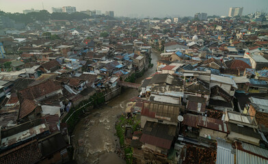 Drone view densely populated residential area with dirty river at Bandung City, 2025. West Java, Indonesia.