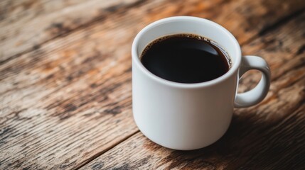 White mug of black coffee on rustic wooden surface. Cozy morning beverage concept