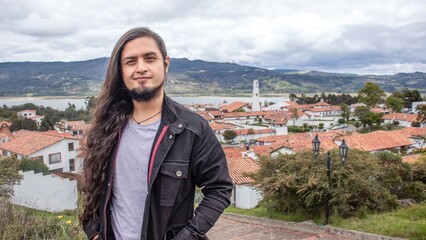 Naklejka premium Traveler - tourist with the landscape of Guatavita, Colombia behind him. View of the lake and the old town of Guatavita in Colombia
