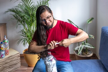 Man recycling plastic at home. Plastic bottles filled with packaging. Making 'Bottles of love'....