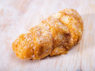 Traditional Catalan deep-fried viennoiserie pastry Xuixo (Chucho) filled with crema catalana