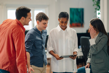 Business team analyzing data on digital tablet in modern office