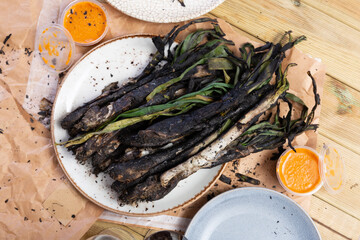 Calcot onion prepared according to catalan traditions served with romesco sauce