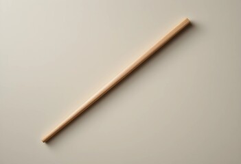A single wooden chopstick rests diagonally on a smooth, neutral surface. Soft lighting highlights its texture and clean edges, creating a minimalist, balanced composition.