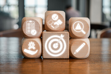 Wooden blocks with icons symbolizing agreement, teamwork, and business strategy on a wooden table.