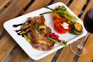 Photography of plate with baked veal with vegetables in restaurante.