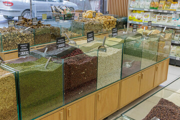 Bulk legumes for sale, with signs in Spanish, in a store.