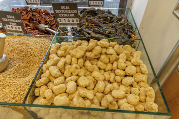 Bulk sale of textured soybeans, with a sign in Spanish, in a store.