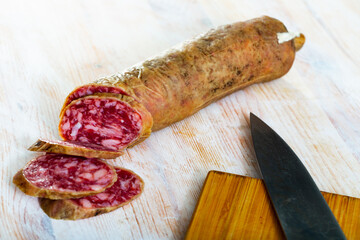 Traditional spanish dry cured pork sausage salchichon sliced on wooden background