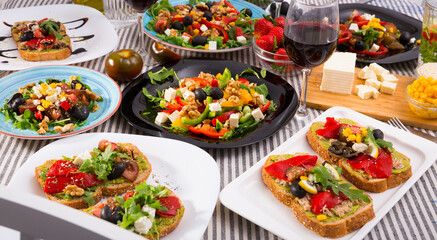 Picture of set of many plates with tasty vegetarian food and glass of wine