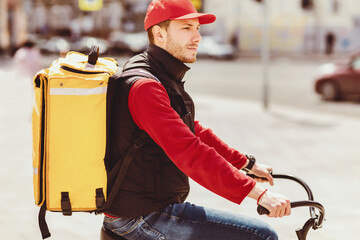 Food Delivery. Courier Guy Riding Bike Delivering Meals In City Outdoors, With Yellow Backpack