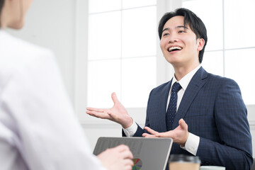 お客様に説明する若手の営業マンなどのイメージ　MRや商談などのイメージ