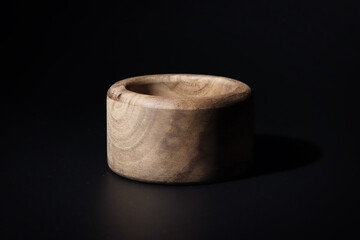 Wooden Bowl on Black Background. Simple Rustic wooden bowl, black background. Natural craftsmanship. Wood texture, aesthetic visual. Decoration, decor, home decor