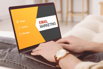 Email marketing. Man using laptop at home, closeup