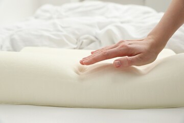 Woman with orthopedic memory foam pillow on bed, closeup. Space for text
