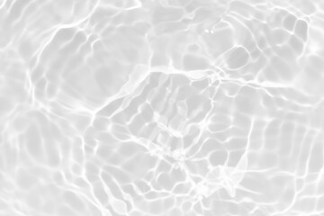 White water with ripples on the surface. Defocus blurred transparent white colored clear calm water surface texture with splashes and bubbles. Water waves with shining pattern texture background.