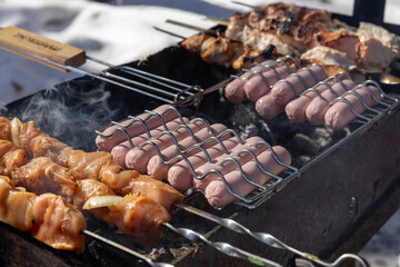 Ready Meat of chicken and pork on skewer and sausages on a Grill Grate Barbecue Food Roasted over Hot charcoal during Grill Season