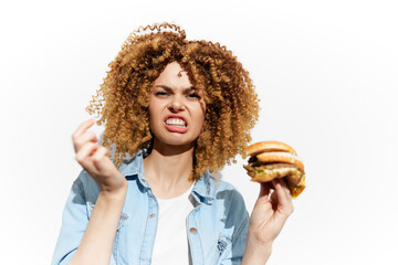 Emotional young woman expressing frustration while holding a fast food burger on a bright...