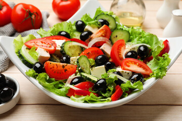 Delicious fresh Greek salad on white wooden table, closeup