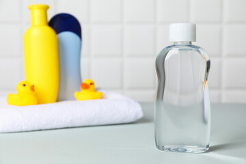 Baby oil and bath accessories on grey table, selective focus