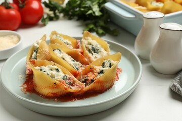 Delicious shell pasta stuffed with ricotta and spinach served on white table, closeup