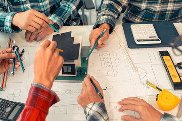 Close-up of industrial engineers team meeting to analyze machinery plans, discuss architectural projects, review construction plans and building plans using tablets at conference table.