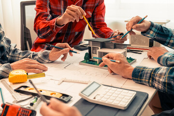 Close-up of industrial engineers team meeting to analyze machinery plans, discuss architectural projects, review construction plans and building plans using tablets at conference table.