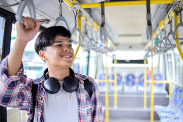 Fototapeta premium Smiling Young Man Holding onto a Handle While Traveling by Public Bus