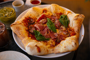 Pizza stella napoletana, a traditional star-shaped pizza from Naples or Napoli, Italy. Added with smoked beef, mozzarella, and parmesan cheese, in a cafe environment