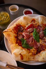 Pizza stella napoletana, a traditional star-shaped pizza from Naples or Napoli, Italy. Added with smoked beef, mozzarella, and parmesan cheese, in a cafe environment