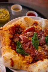 Pizza stella napoletana, a traditional star-shaped pizza from Naples or Napoli, Italy. Added with smoked beef, mozzarella, and parmesan cheese, in a cafe environment