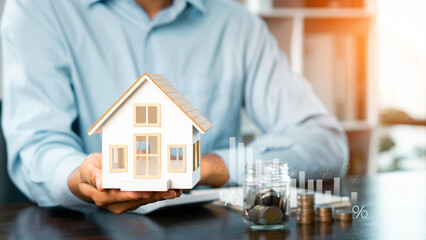 Businessman holding model house showing real estate market growth, real estate and investment concept, real estate market analysis or economic development concept.