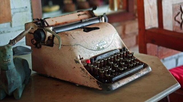 Antique cast iron typewriter with mechanical keyboard stands on wooden table
