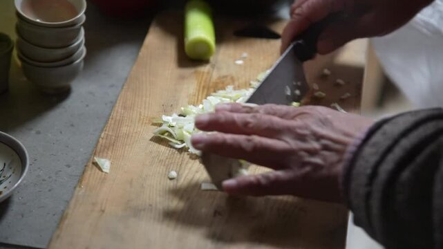 ネギをみじん切りする女性