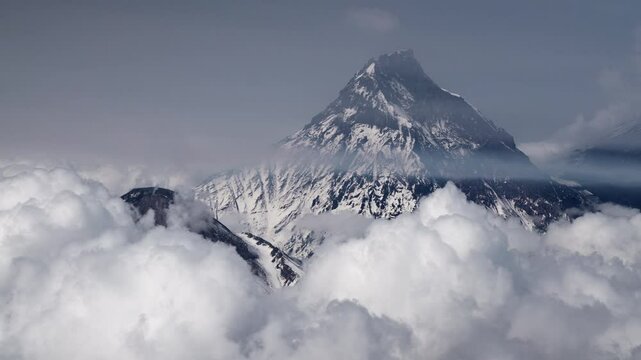 Winter mountains in clouds and bursts of steam from fumaroles