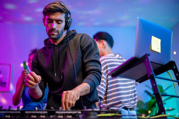 Caucasian young man artist DJ mixing and scratching music mixer controller. 