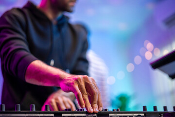 Close up of man artist DJ mixing and scratching music mixer controller. 